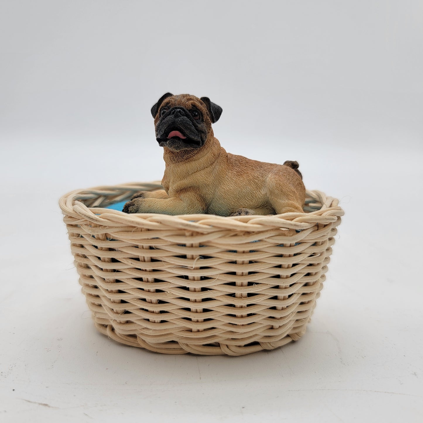 Pug Laying in a Basket Figurine