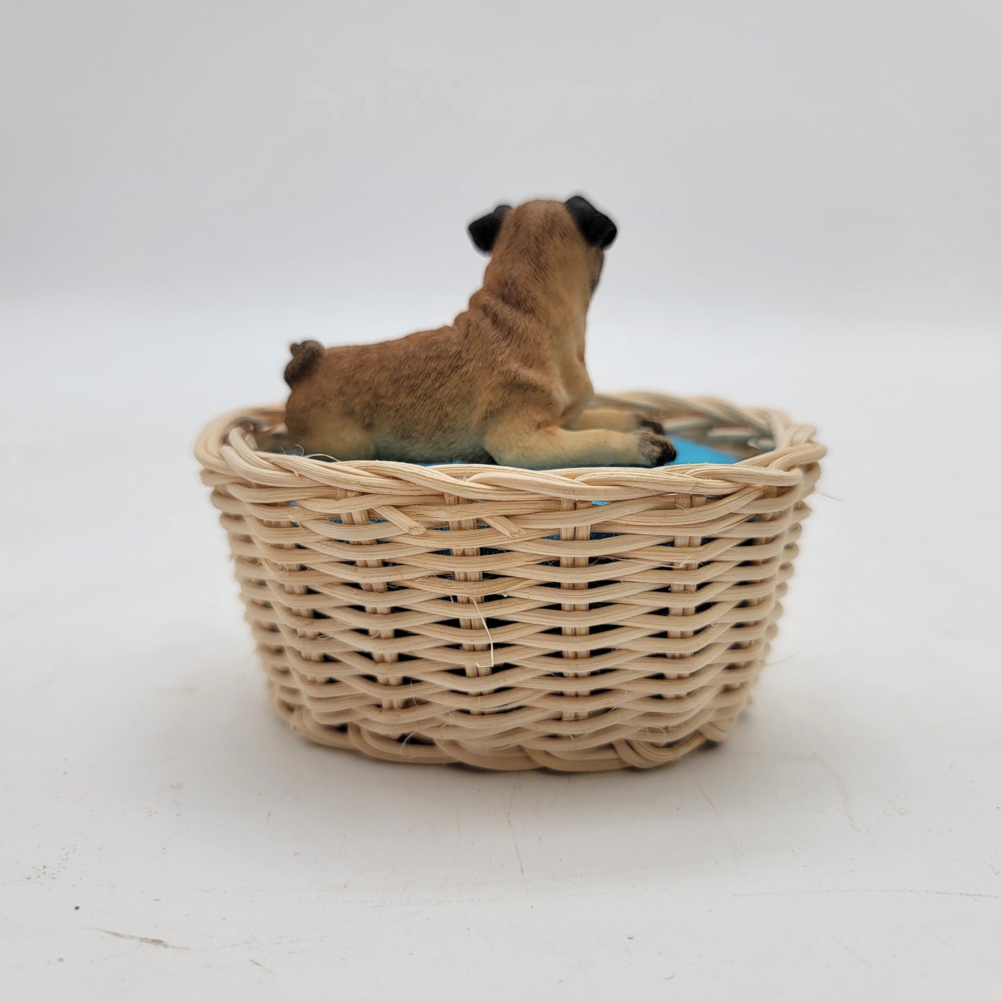 Pug Laying in a Basket Figurine