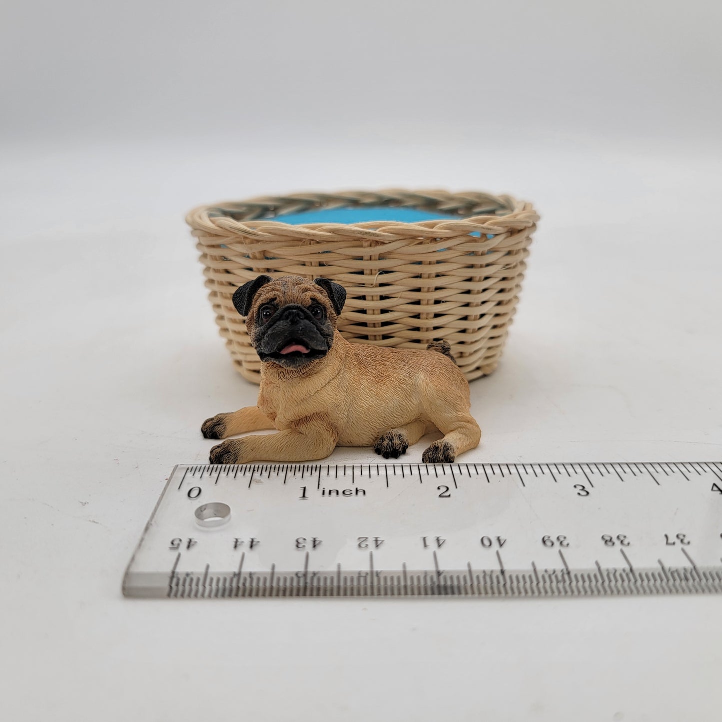 Pug Laying in a Basket Figurine