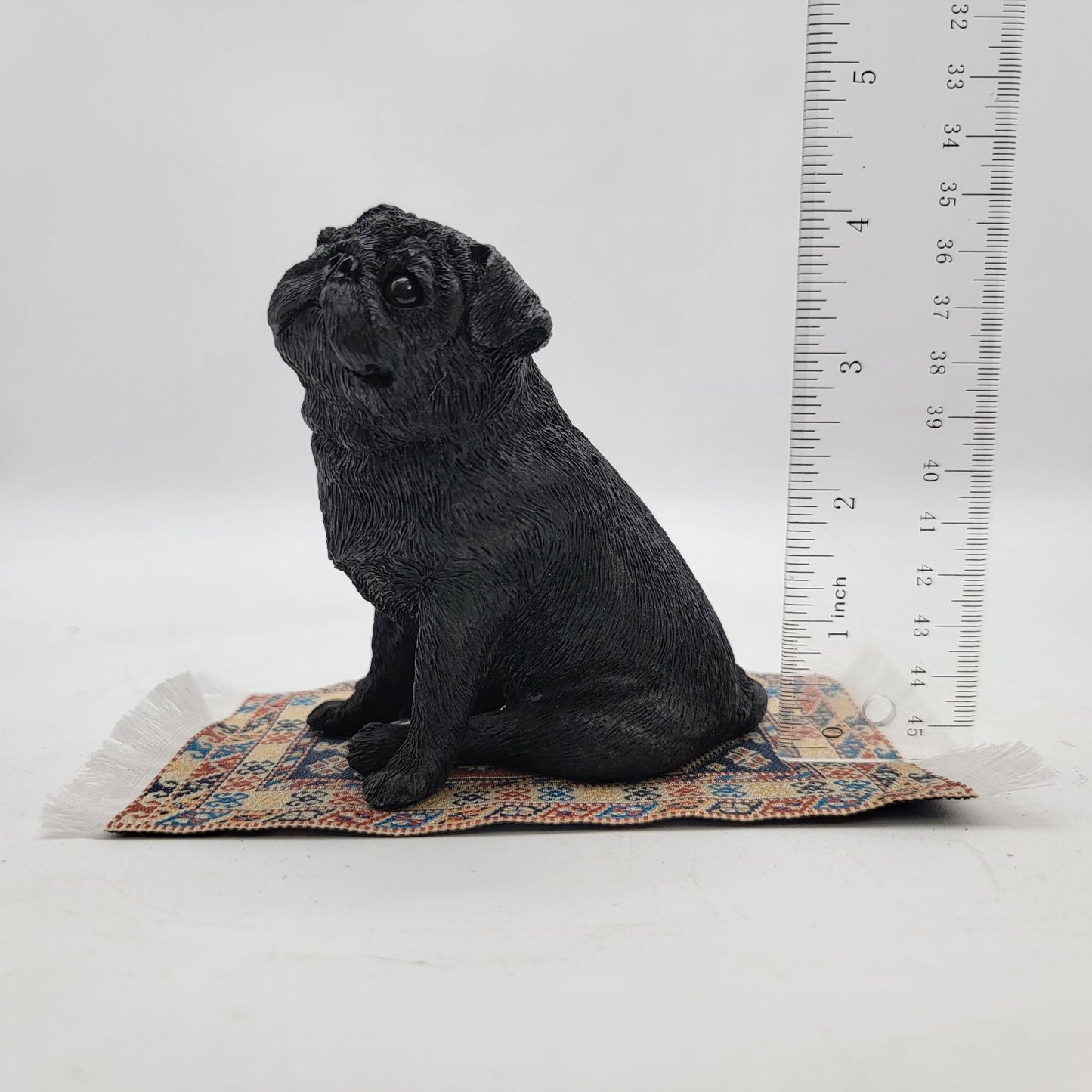 Black Pug Figurine On Miniature Oriental Rug