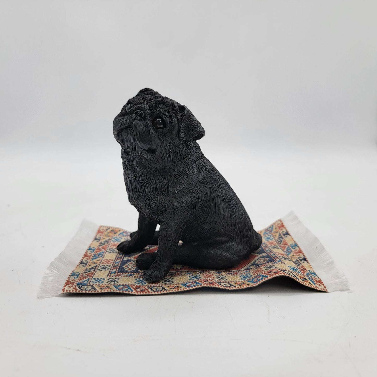 Black Pug Figurine On Miniature Oriental Rug