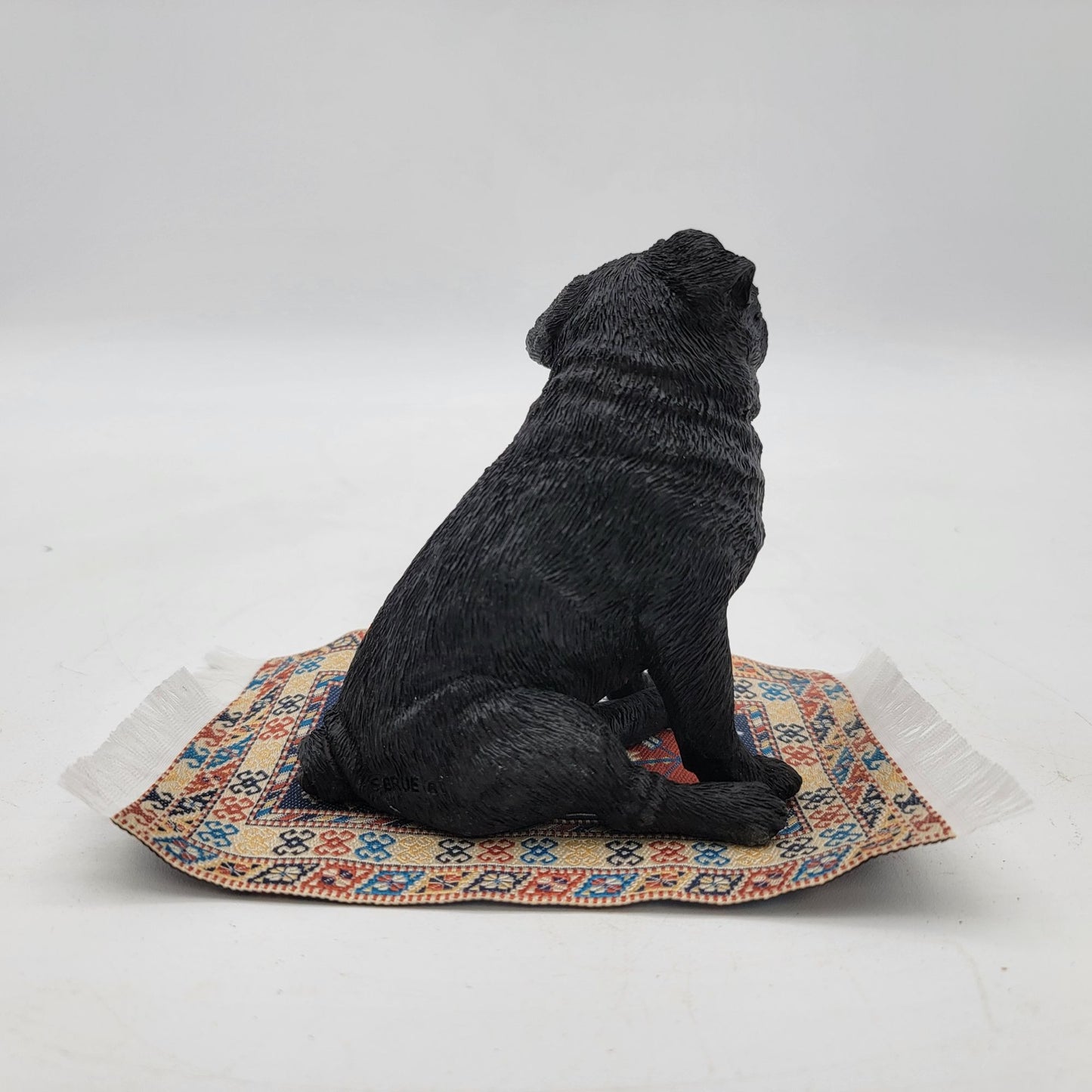 Black Pug Figurine On Miniature Oriental Rug