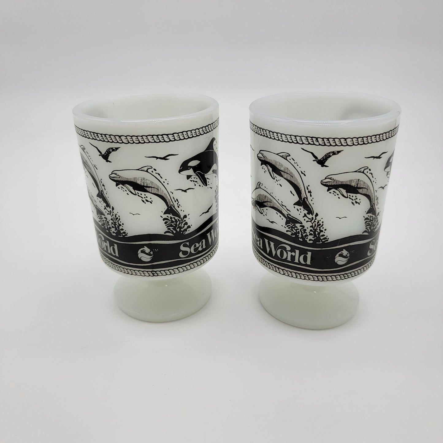 Pair of 1980 Vintage Fire King Milk Glass Sea World Footed Mugs Dolphin Orca Design