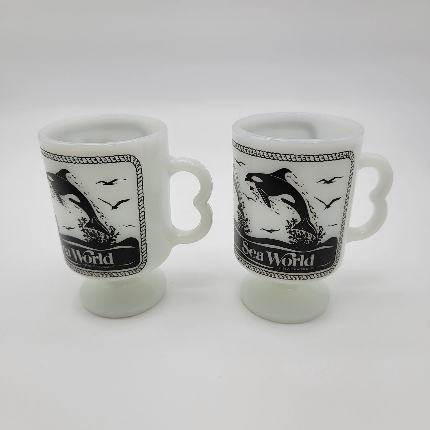 Pair of 1980 Vintage Fire King Milk Glass Sea World Footed Mugs Dolphin Orca Design