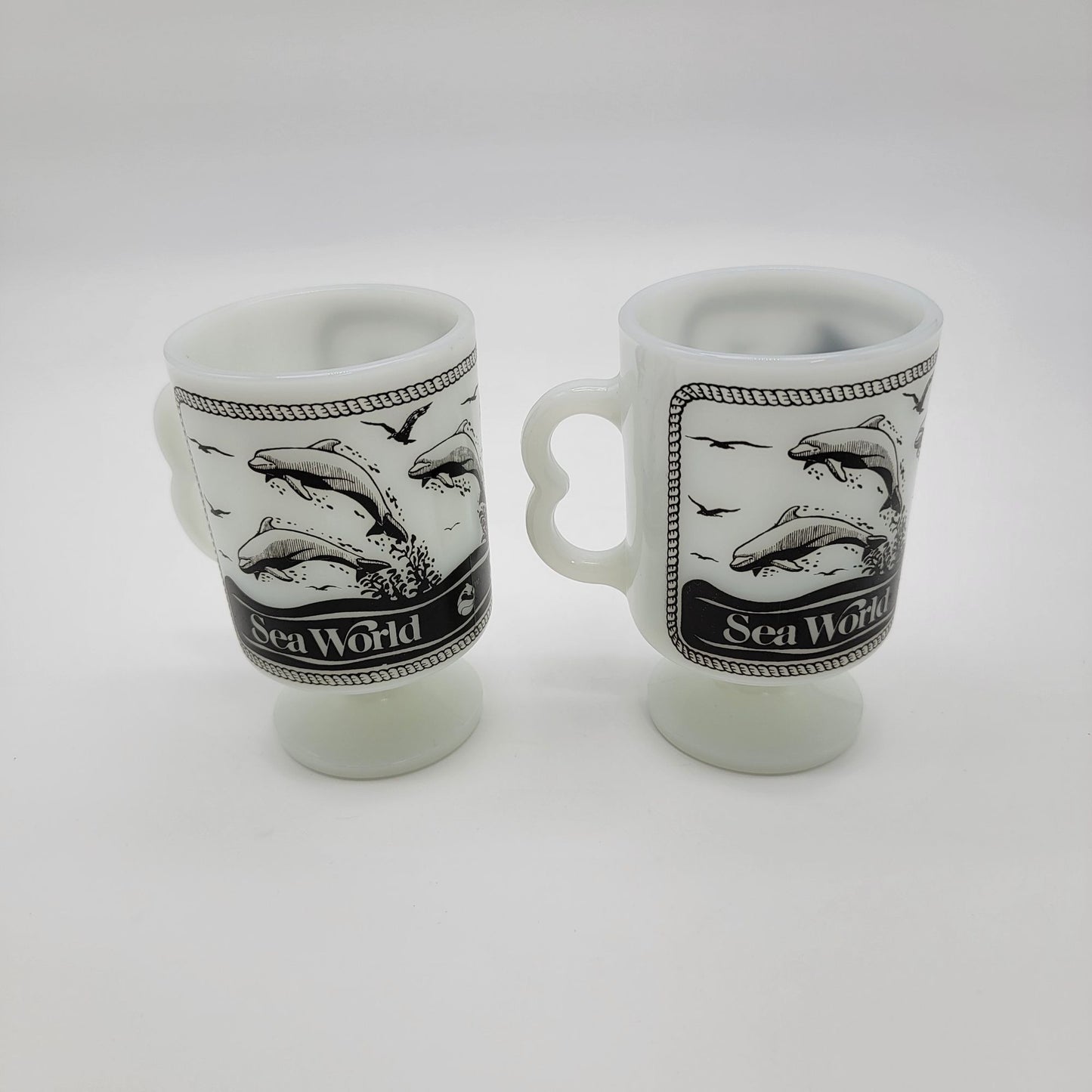 Pair of 1980 Vintage Fire King Milk Glass Sea World Footed Mugs Dolphin Orca Design